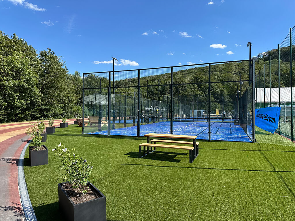 Padelplätze am Standort Marswiese in Wien 17 mit Sitzbank und gepflegter Außenanlage.