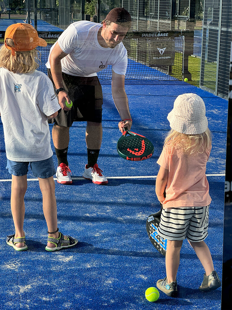Padeltrainer erklärt Kindern die Grundlagen des Padelspiels auf der Marswiese.