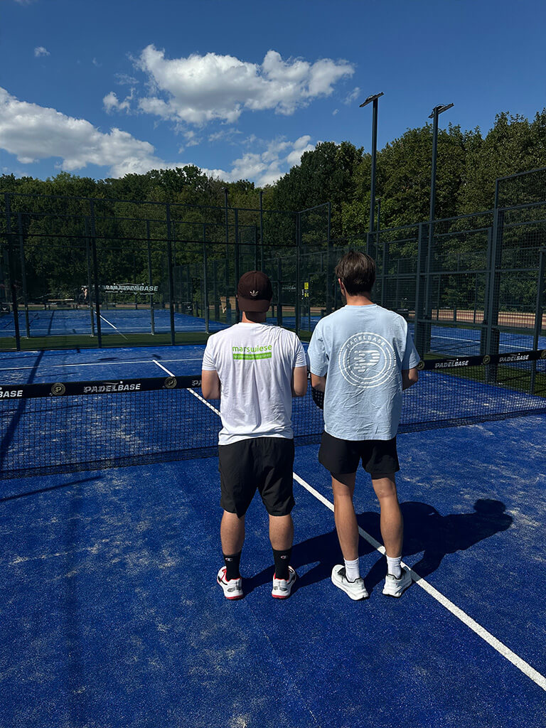 Zwei Padel-Trainer auf einem Outdoor-Padelplatz an der Marswiese in Wien.